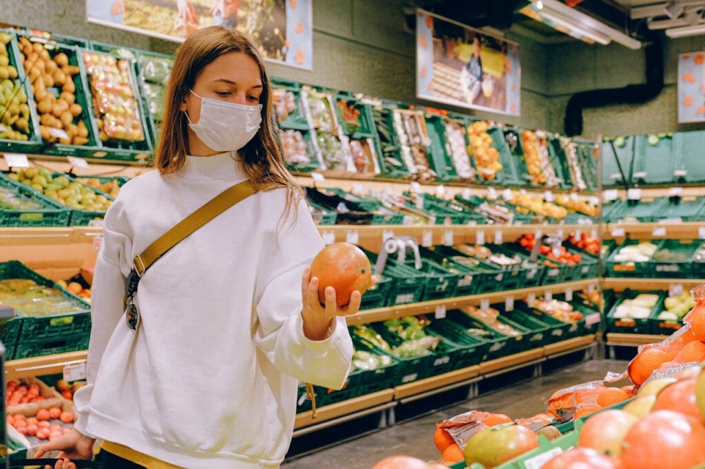 pexels photo 3962287 Woman wearing a face mask choosing fruits in a supermarket for safe shopping during pandemic.