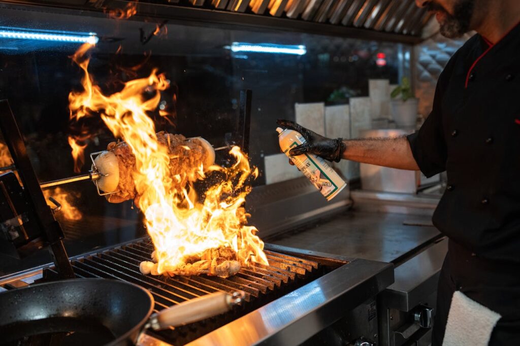 pexels photo 5779786 Chef uses a culinary torch to ignite a flaming grill indoors, showcasing dynamic cooking.
